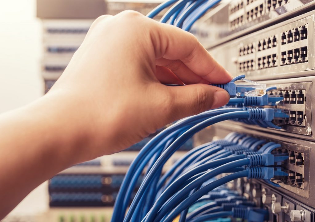 hand with network cable in a technology data center
